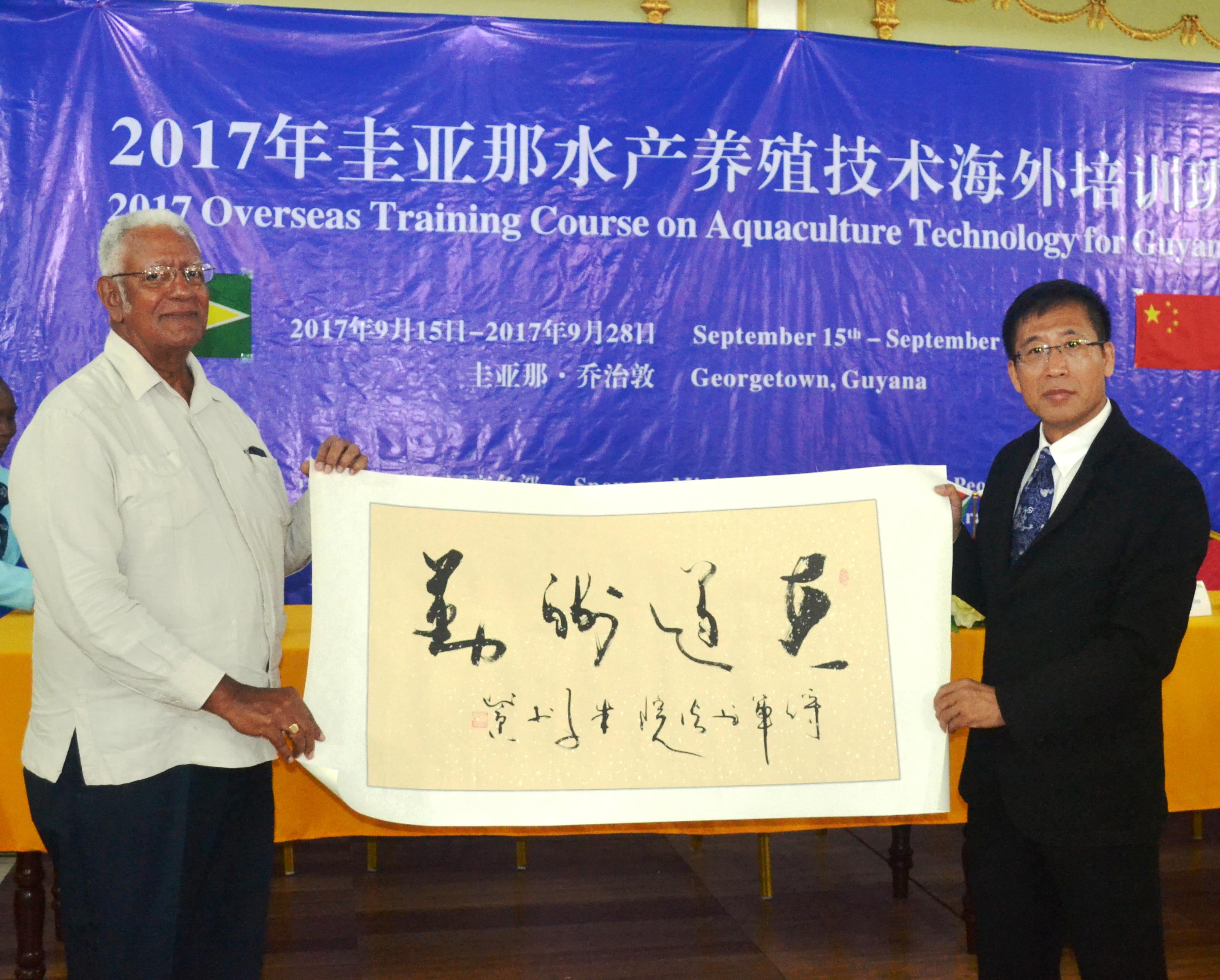 Minister Holder receives a token from Mr. Mingzhe