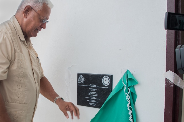 Minister of Agriculture, Noel Holder unveils the plaque commemorating the building.