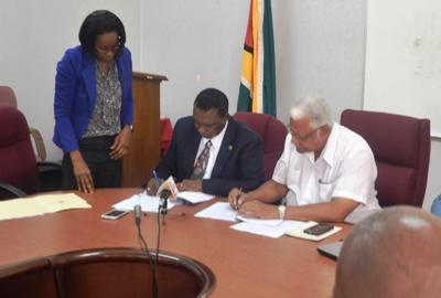 Minister of Agriculture Noel  Holder and FAO Representative Mr Ruben Robertson signs the four year country  program