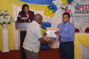 chairman-of-the-ptccb-dr-leslie-munroe-presents-a-certificate-to-a-graduate-at-the-ptccb-graduation-ceremony-as-registrar-of-the-ptccb-trecia-garnath-in-background-looks-on