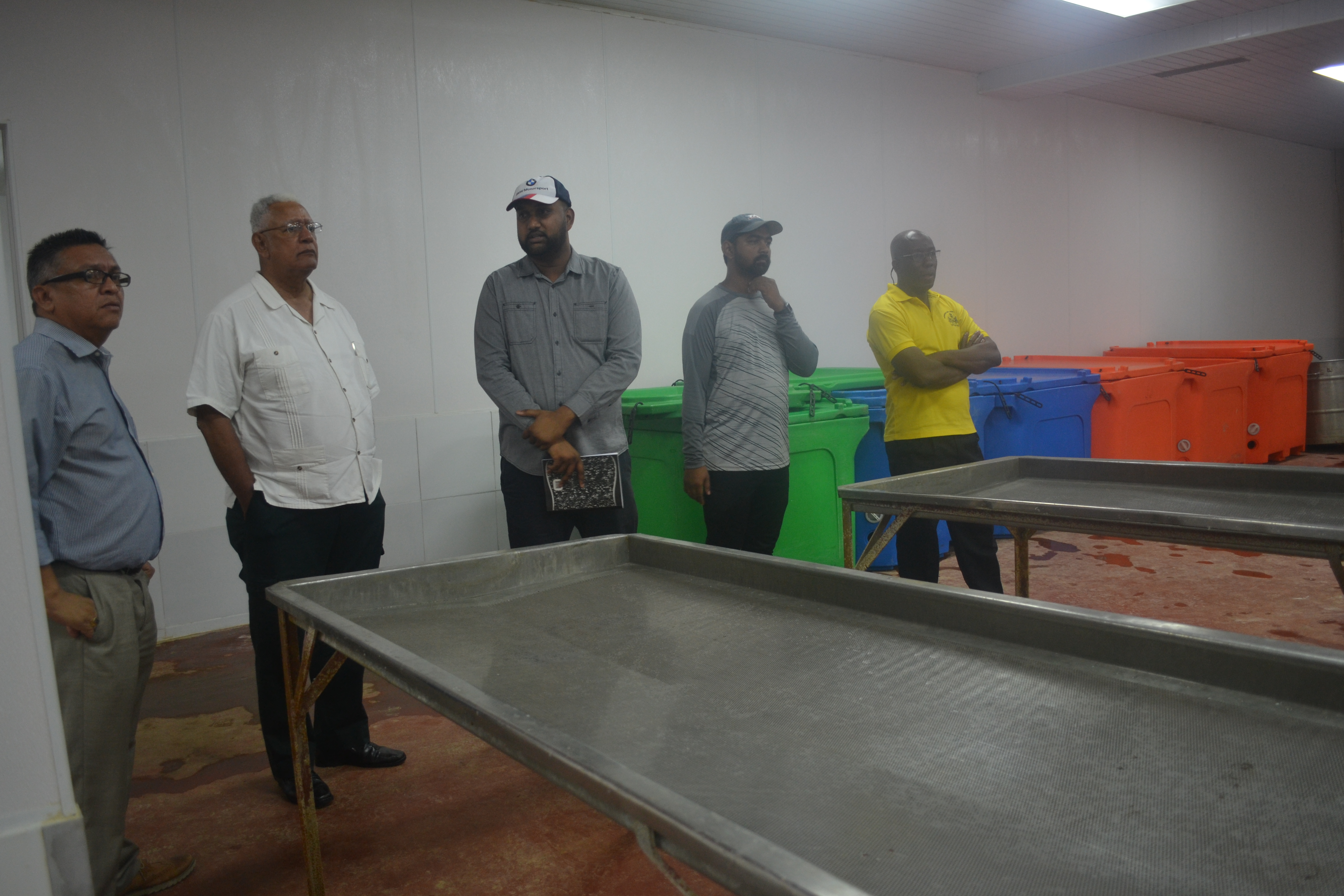 Minister Holder and other officials while touring Gopie Investments Inc's shimp processing facility