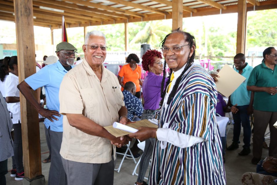 Ras Dalgety receives his lease from Minister of Agriculture, Noel Holder